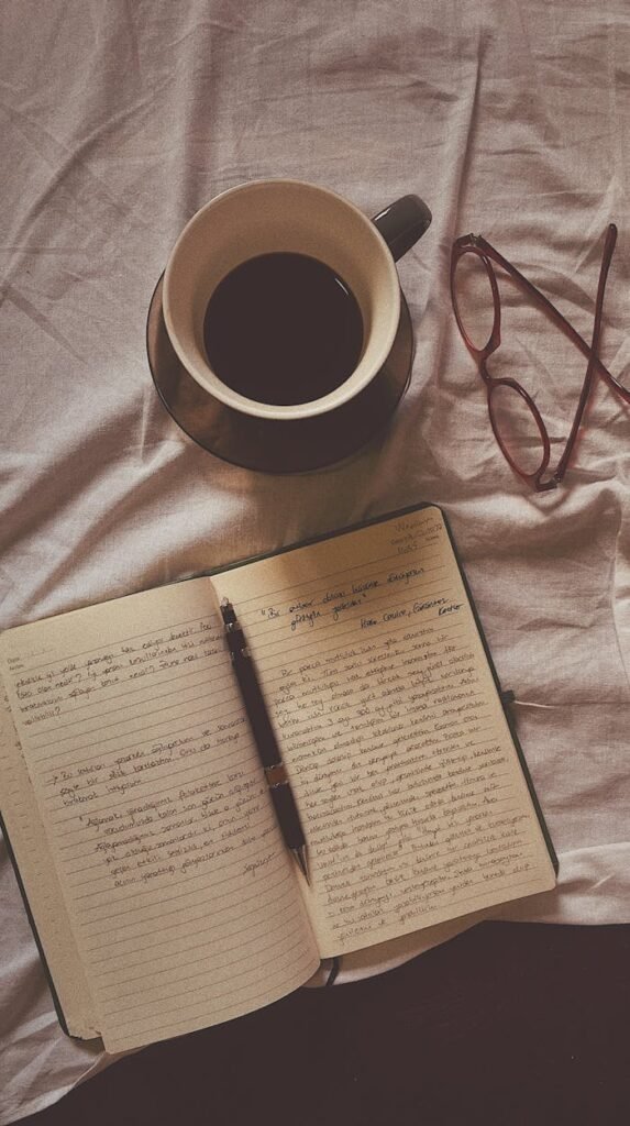 A book, glasses and coffee are on a bed